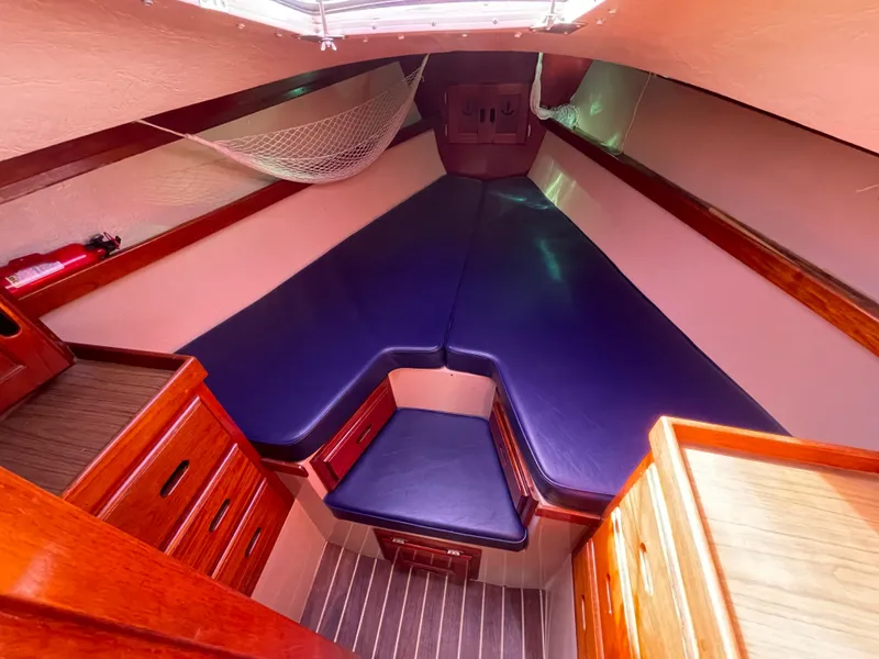 Slide: The Image of 1980 Catalina 38 sailboat interior with blue cushions and wooden cabinetry. - 21