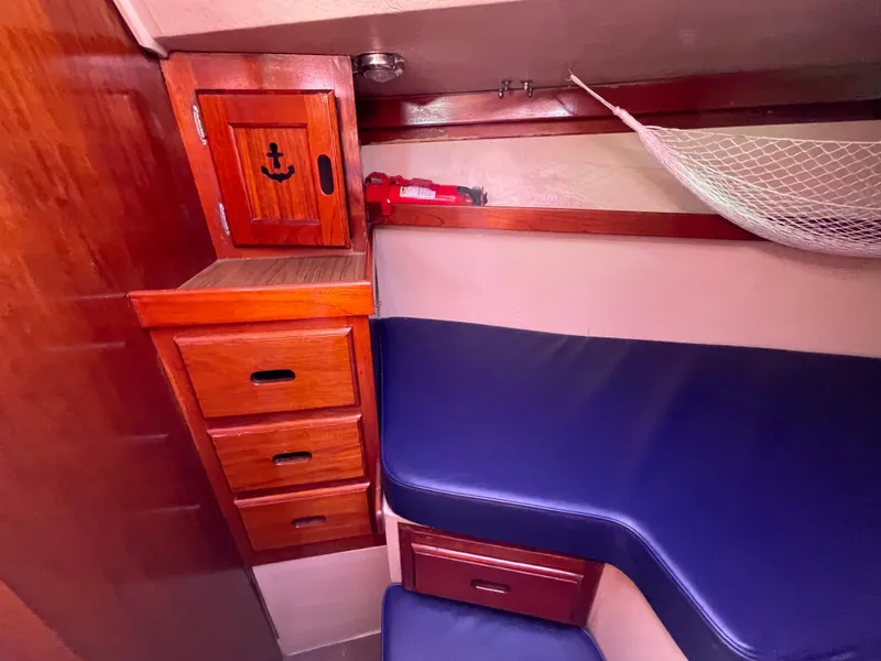 Slide: The Image of Interior of 1980 Catalina 38 sailboat with wooden cabinets and blue cushions. - 22
