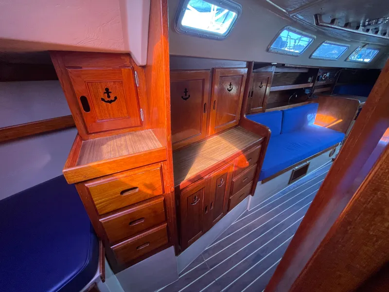 Slide: The Image of Interior of 1980 Catalina 38 sailboat with wooden cabinets and blue seating. - 23