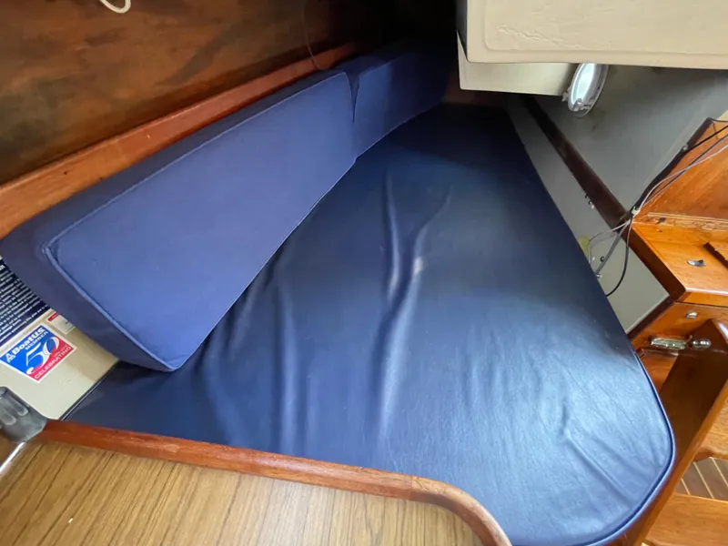 Slide: The Image of Interior cabin of 1980 Catalina 38 sailboat with blue cushions and wooden accents. - 26
