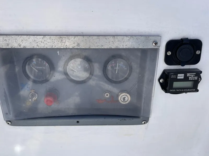 Slide: The Image of Control panel of a 1980 Catalina 38 sailboat with gauges and a Tiny Tach display. - 30