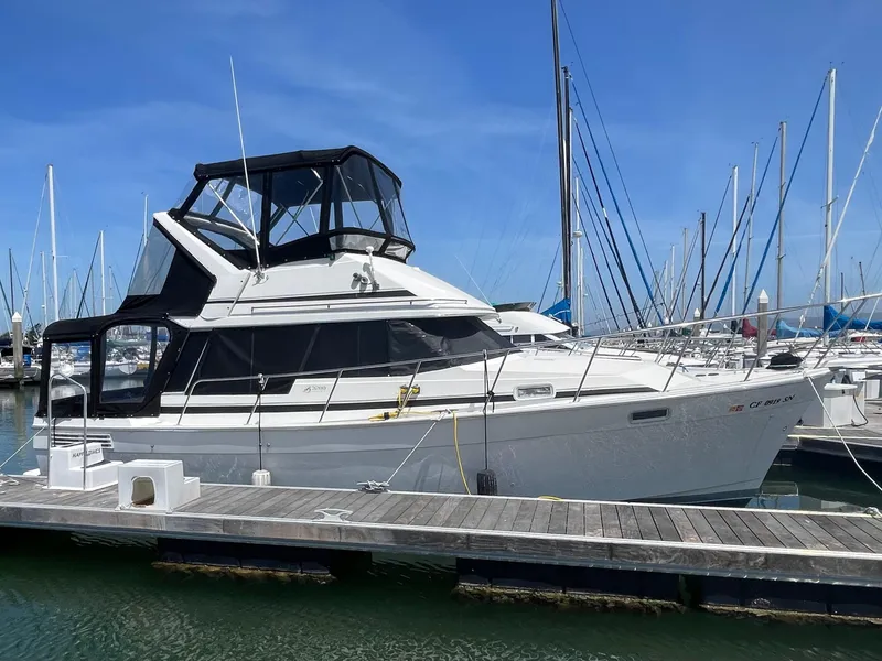 Slide: The Image of 1989 Bayliner 3288 yacht docked at marina under clear blue sky. - 0