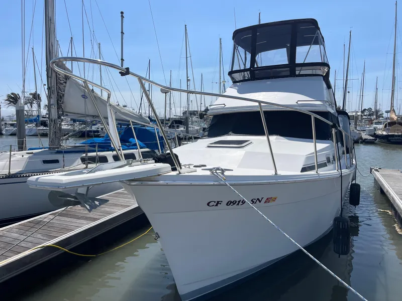 Slide: The Image of 1989 Bayliner 3288 yacht docked at marina, surrounded by sailboats. - 1