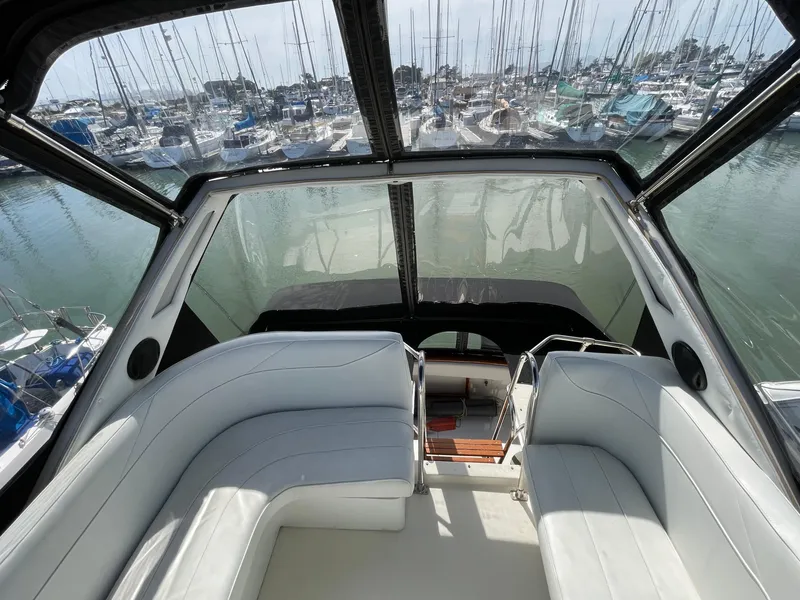 Slide: The Image of 1989 Bayliner 3288 boat interior with white seating, docked in a marina. - 11
