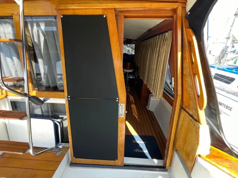 Slide: The Image of 1989 Bayliner 3288 boat interior with wooden sliding door and curtains. - 12