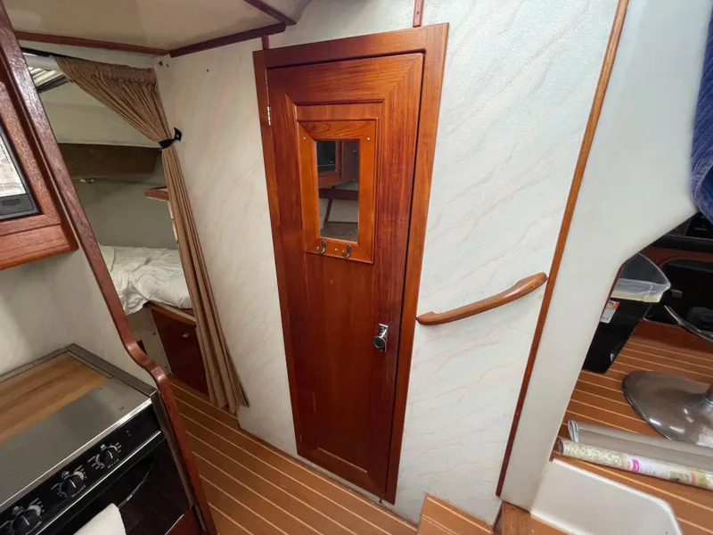 Slide: The Image of Interior of 1989 Bayliner 3288 boat with wooden door and cozy cabin space. - 17