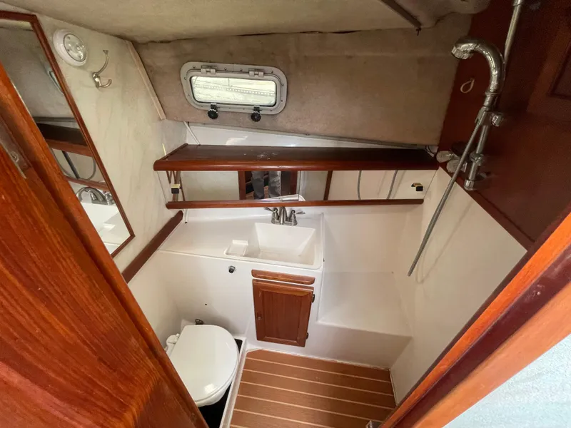 Slide: The Image of 1989 Bayliner 3288 boat bathroom with sink, toilet, and wooden accents. - 18
