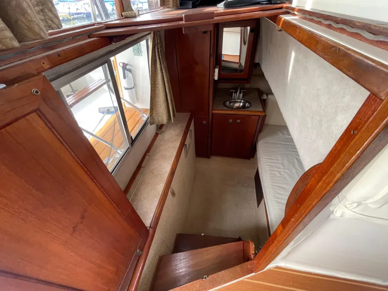 Slide: The Image of 1989 Bayliner 3288 cabin interior with wood finish, sink, and seating area. - 22