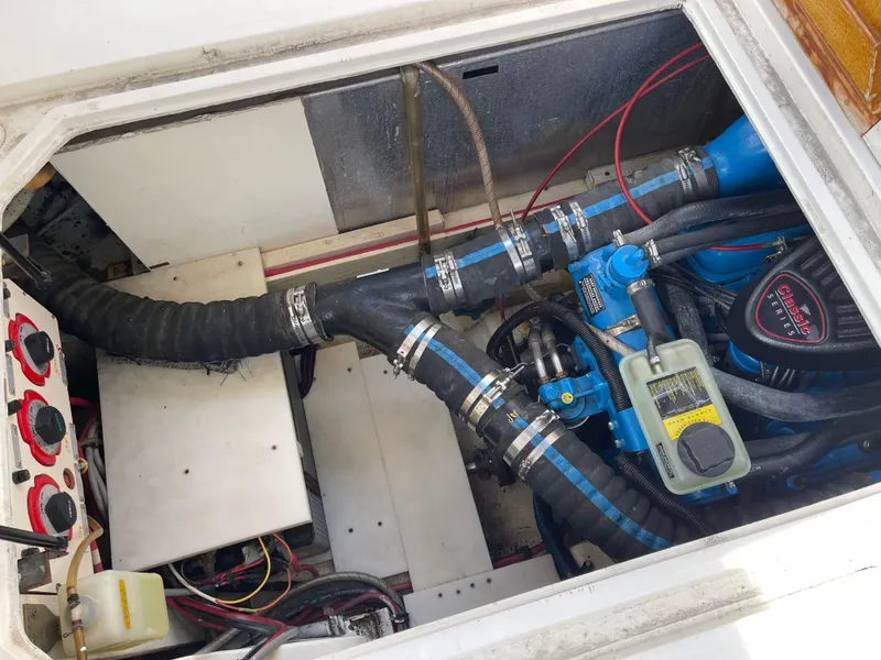 Slide: The Image of Engine compartment of a 1989 Bayliner 3288 boat, showcasing hoses and mechanical components. - 25