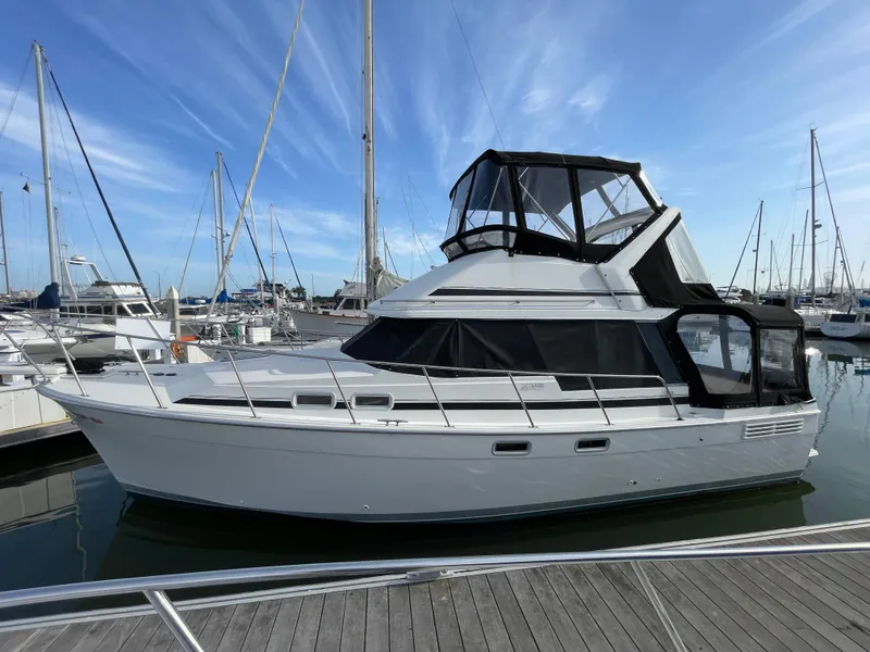 Slide: The Image of 1989 Bayliner 3288 yacht docked at marina under clear blue sky. - 30