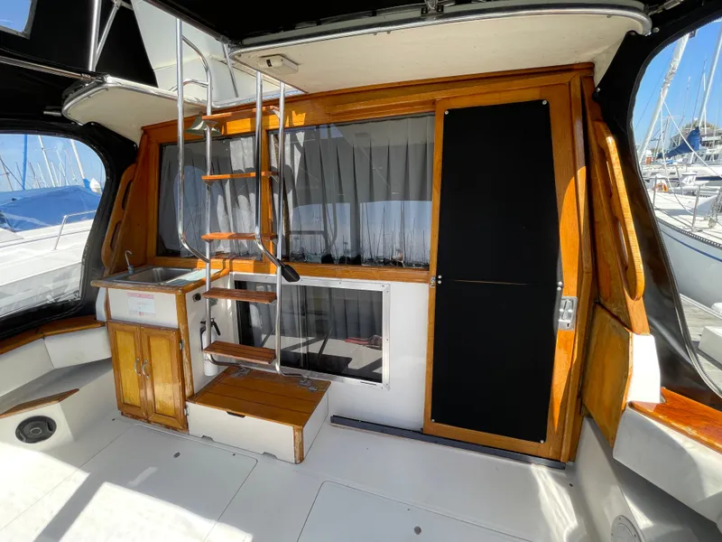 Slide: The Image of 1989 Bayliner 3288 boat interior with wooden accents, ladder, and small sink area. - 5
