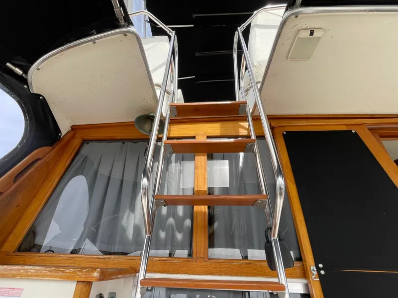 Slide: The Image of Staircase on 1989 Bayliner 3288 yacht, featuring wooden steps and metal railings. - 7