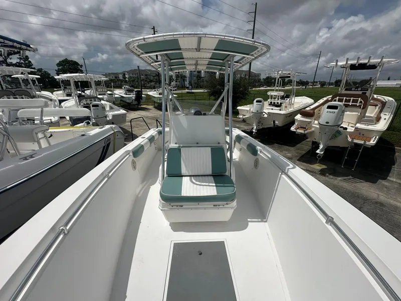 Slide: The Image of 2007 Contender 21 Open boat with seating, parked among other boats under cloudy skies. - 7