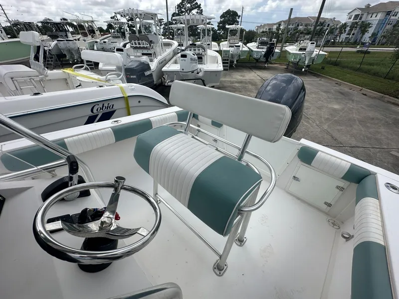 Slide: The Image of 2007 Contender 21 Open boat interior with steering wheel and seating, docked among other boats. - 9