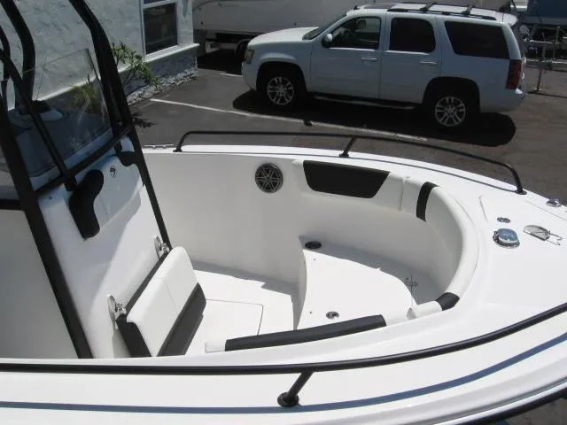 Slide: The Image of 2025 Edgewater 208 WATCHMAN CC boat interior with seating and console, parked near SUV. - 5