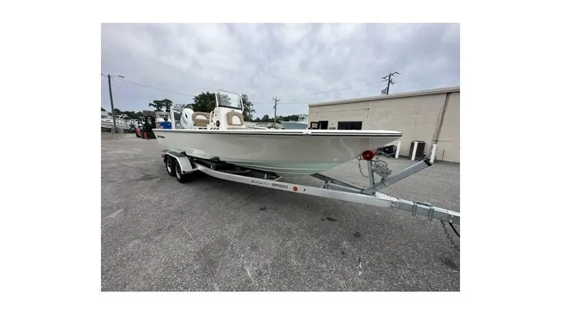 Slide: The Image of 2024 Sea Born FX22 Bay boat on trailer in parking lot. - 2