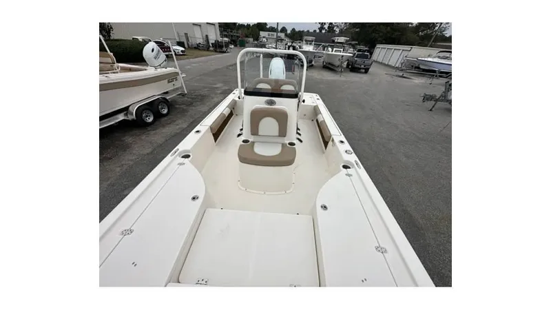 Slide: The Image of 2024 Sea Born FX22 Bay boat, spacious deck, beige seating, parked in marina. - 4