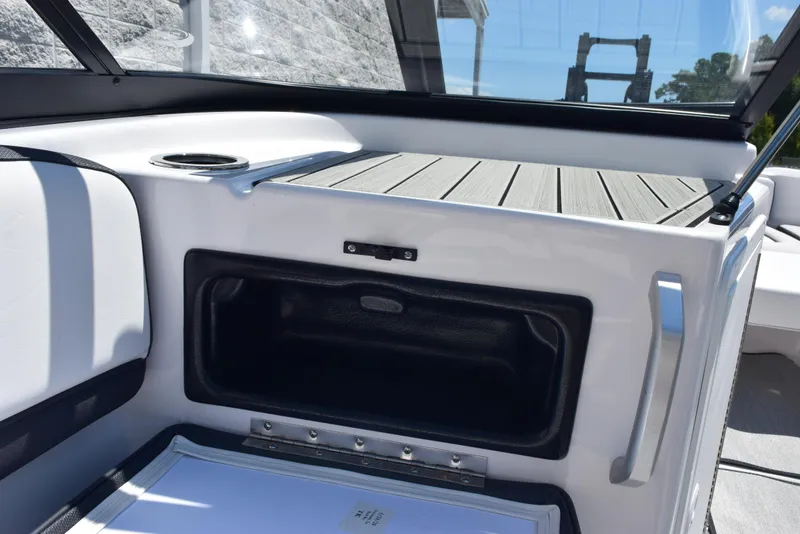 Slide: The Image of 2025 Yamaha AR195 boat interior with storage compartment and cup holder. - 17