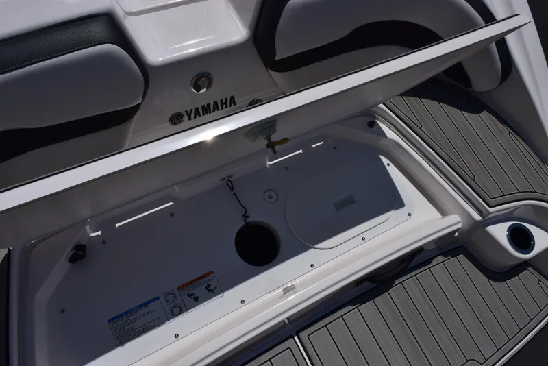 Slide: The Image of 2025 Yamaha Boats AR195 storage compartment with open lid, showcasing interior design and features. - 20