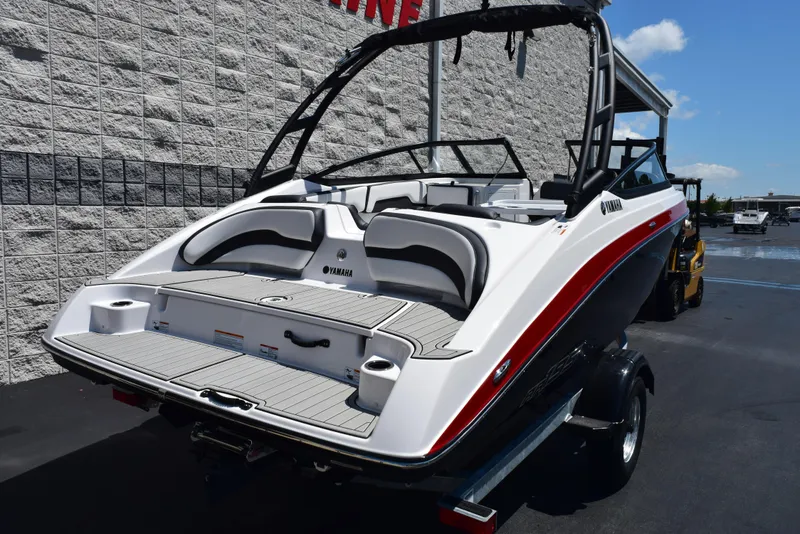 Slide: The Image of 2025 Yamaha Boats AR195, sleek design, white and red, parked outdoors. - 3