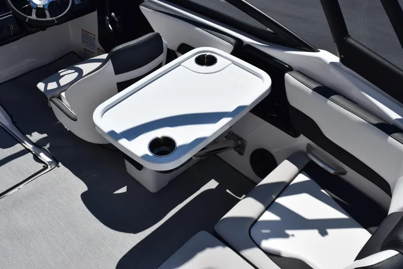 Slide: The Image of 2025 Yamaha Boats AR195 interior with seating and table, featuring cup holders. - 9