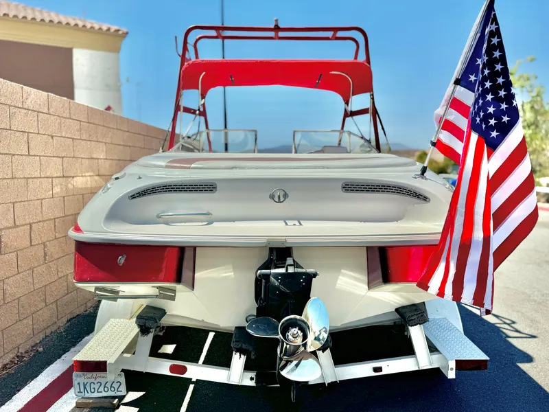 Slide: The Image of 1998 VIP Vixen boat with American flag, red canopy, and trailer. - 5