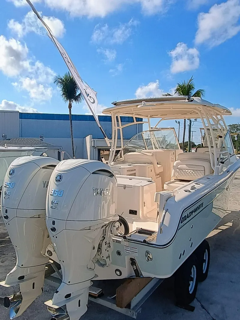 Slide: The Image of 2025 Grady-White Freedom 285 boat with dual engines, docked under a clear blue sky. - 3