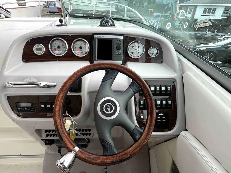 Slide: The Image of 2007 Chaparral 275 SSi boat dashboard with wood-trimmed steering wheel and gauges. - 18