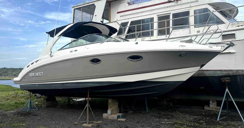Slide: The Image of 2007 Chaparral 275 SSi boat on stands, docked beside a larger vessel. - 3
