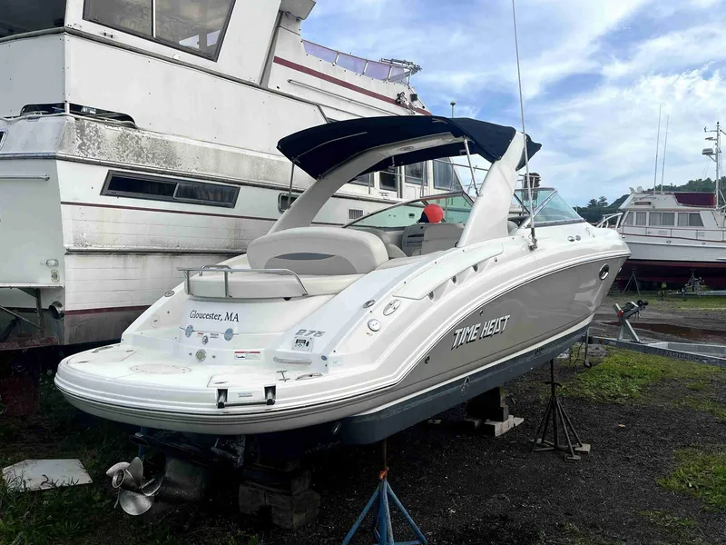 Slide: The Image of 2007 Chaparral 275 SSi boat on land, white hull, black canopy, parked near other boats. - 5