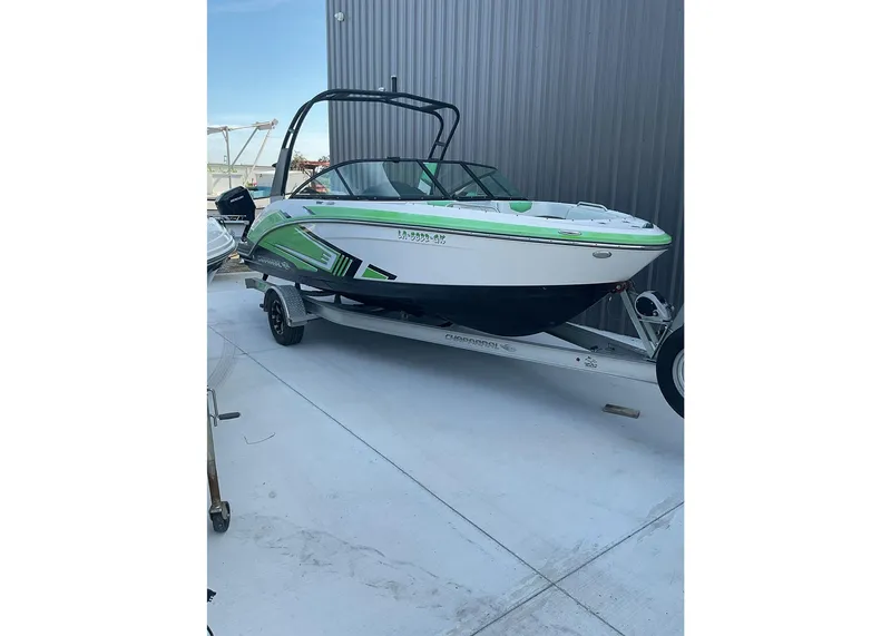 Slide: The Image of 2016 Chaparral Vector 203 boat on trailer, green and white design, parked outdoors. - 5