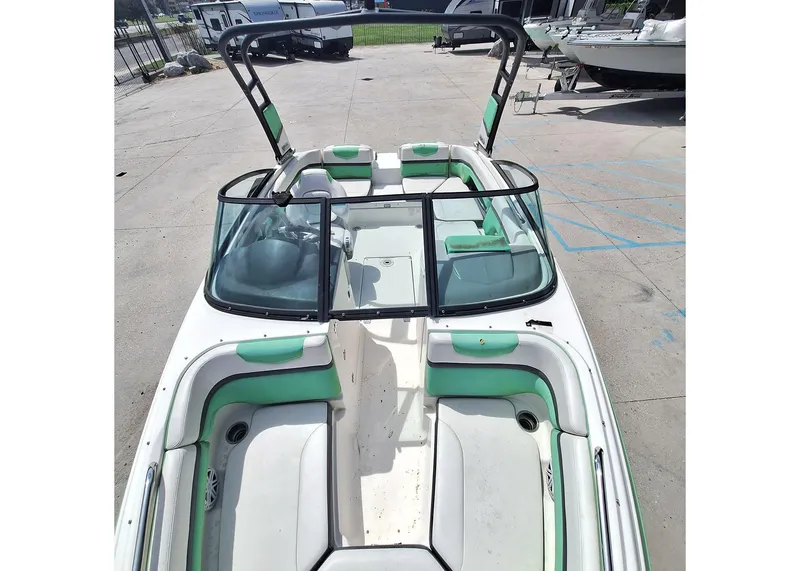 Slide: The Image of 2016 Chaparral Vector 203 boat with green accents, docked outdoors. - 9