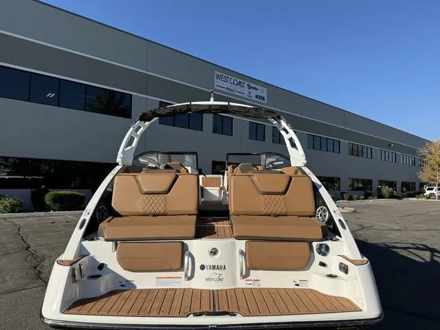 Slide: The Image of 2024 Yamaha Boats 252S with tan seating, displayed outdoors. - 3