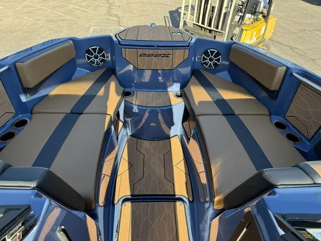 Slide: The Image of 2024 Yamaha Boats 222XD interior with blue and brown seating, cup holders, and speakers. - 6