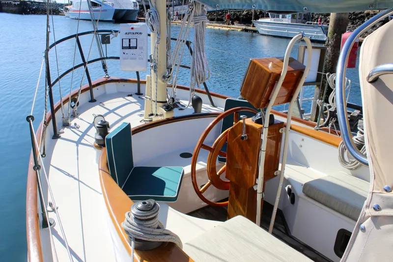 Slide: The Image of Sailboat cockpit of 2012 Custom Gartside Jespersen 40, featuring wooden wheel and seating. - 19