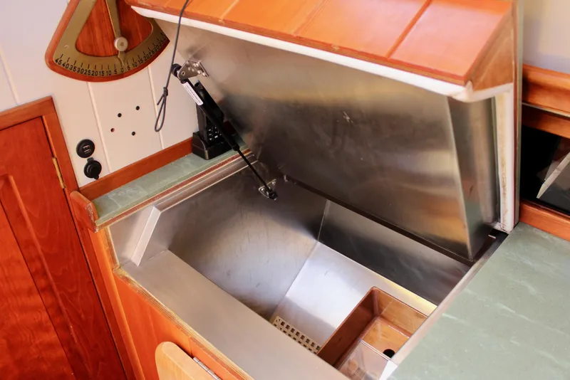 Slide: The Image of Open storage compartment on 2012 Custom Gartside Jespersen 40 boat, featuring wooden and metal finishes. - 44