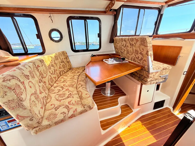 Slide: The Image of Interior of 2009 Ranger Tugs R-29 with patterned seating and wooden table. - 12