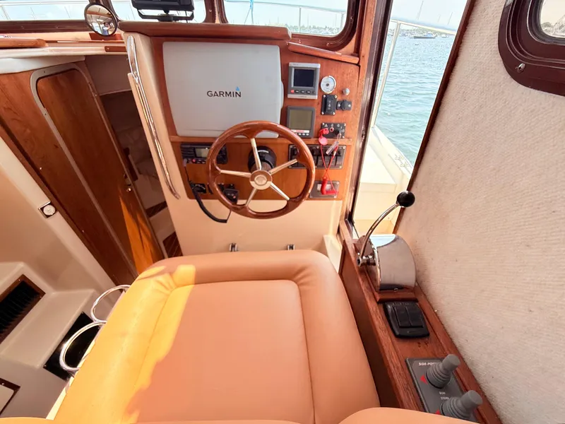 Slide: The Image of 2009 Ranger Tugs R-29 helm with Garmin navigation, wooden steering wheel, and control panel. - 14