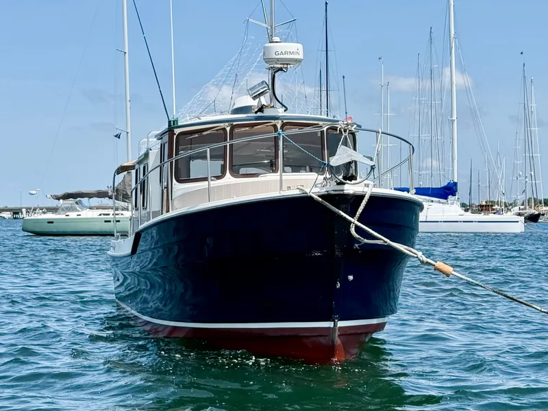 Slide: The Image of 2009 Ranger Tugs R-29 boat anchored in a marina with sailboats in the background. - 3
