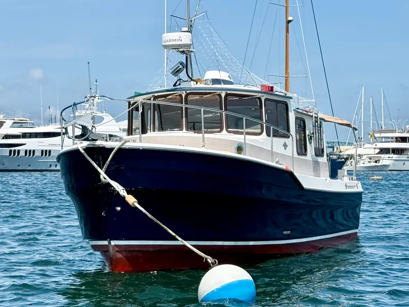 Slide: The Image of 2009 Ranger Tugs R-29 boat anchored in marina with clear blue sky. - 5