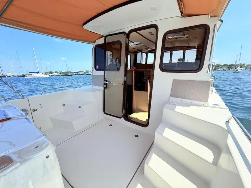 Slide: The Image of 2009 Ranger Tugs R-29 boat deck with open cabin door, overlooking marina. - 8