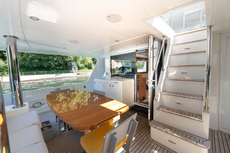 Slide: The Image of Luxurious 2022 Outer Reef Yachts 720 Motoryacht interior with dining area and staircase. - 16