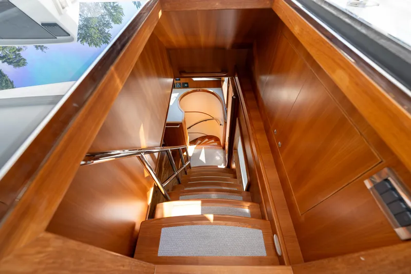 Slide: The Image of Interior staircase of 2022 Outer Reef Yachts 720 Motoryacht, featuring elegant wood finish. - 26