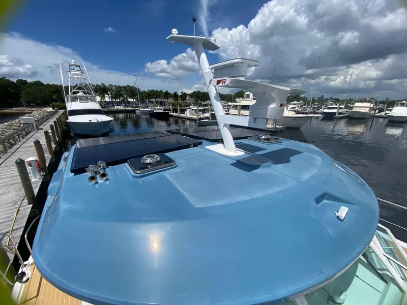 Slide: The Image of 2007 Manta 44 Power Cat on a sunny marina, showcasing its sleek blue deck. - 10