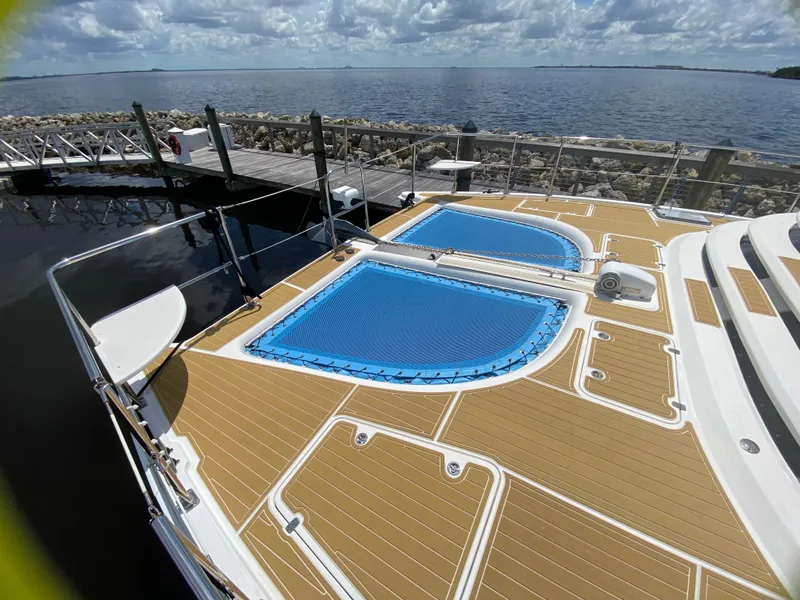 Slide: The Image of 2007 Manta 44 Power Cat deck with blue netting, docked by the water. - 13