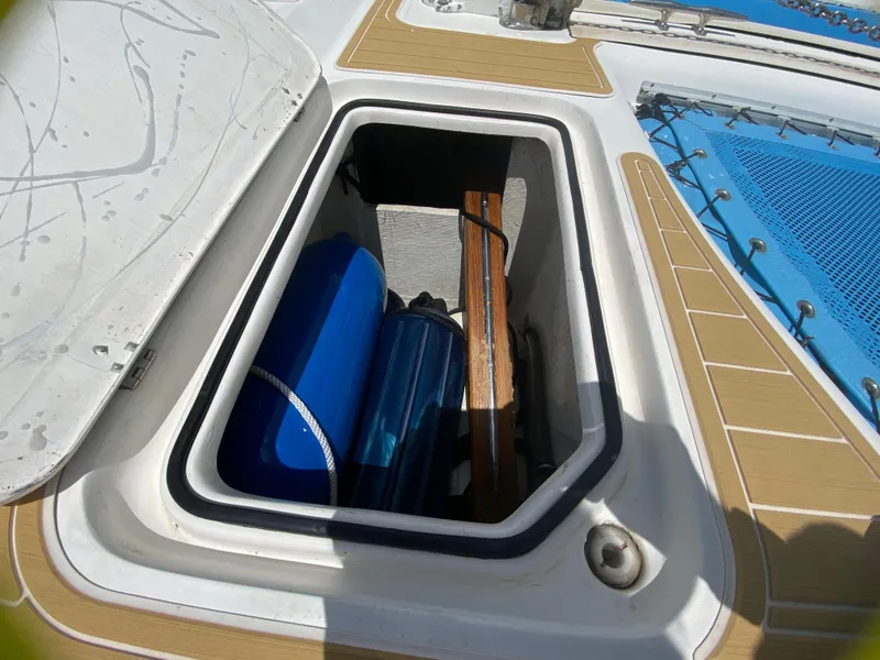 Slide: The Image of Storage compartment on 2007 Manta 44 Power Cat with blue tanks and wooden items. - 16