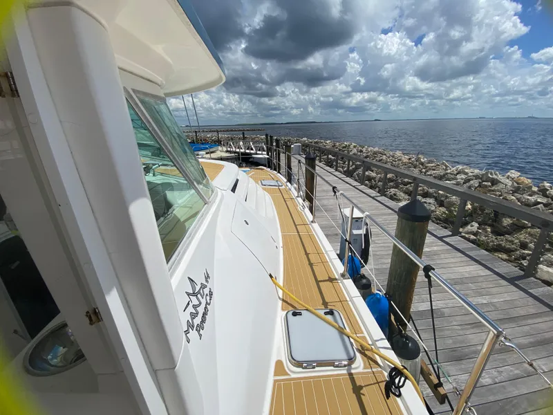 Slide: The Image of 2007 Manta 44 Power Cat docked by the sea under a cloudy sky. - 17