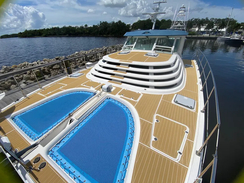 Slide: The Image of 2007 Manta 44 Power Catamaran docked, featuring spacious deck and blue netting. - 4