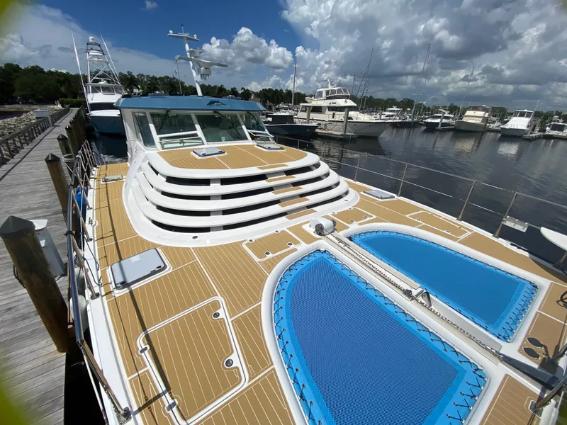 Slide: The Image of 2007 Manta 44 Power Cat docked at marina, featuring spacious deck and blue netting. - 5