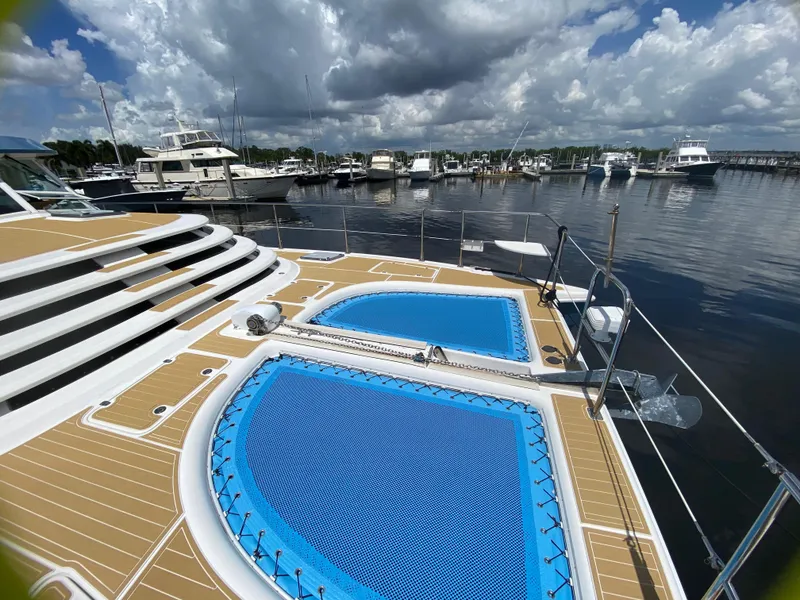 Slide: The Image of 2007 Manta 44 Power Cat with netted deck, docked at marina under cloudy sky. - 7